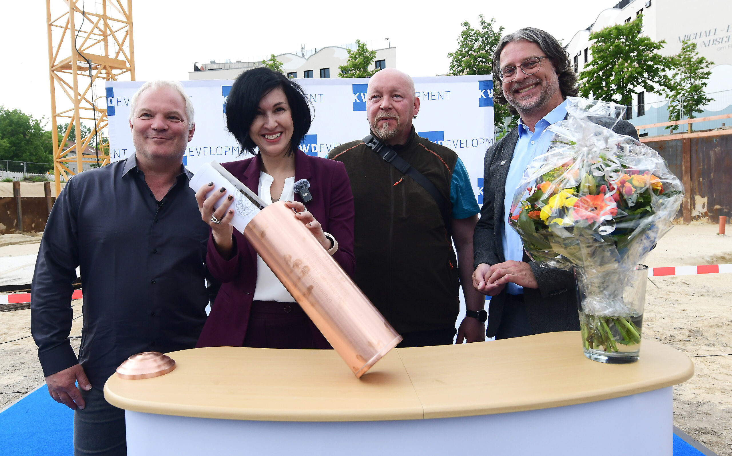 Potsdams Oberbürgermeisterin Noosha Aubel befüllt die Zeitkapsel für die Grundsteinlegung. Mit dabei sind Jan Kretzschmar, Geschäftsführer von KW-Development, Bauleiter Jack Lipke und Projektleiter Sebastin Gleue von KW-Development.
