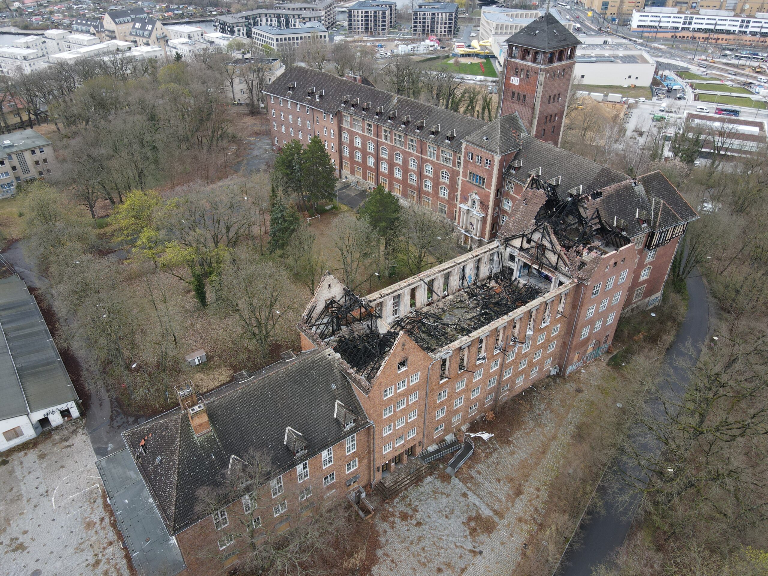 Ein Luftbild von einem alten Gebäude mit einem durch einen Brand zerstörten Dach.
